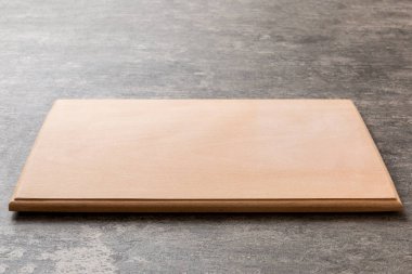 Çimento arka planında tahta kesme tahtası manzarası. Tasarımın için boş boşluk.