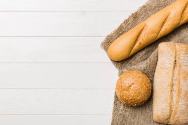 Kırsal masa manzaralı peçeteli taze pişmiş ekmek çeşitleri. Sağlıklı mayasız ekmek. Fransız ekmeği.