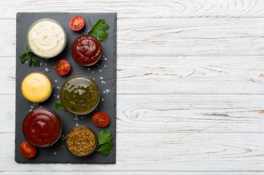 Masada bir sürü farklı sos ve bitki vardı, düz bir manzarası vardı. Tabakta soslar, sağlıklı konsept..