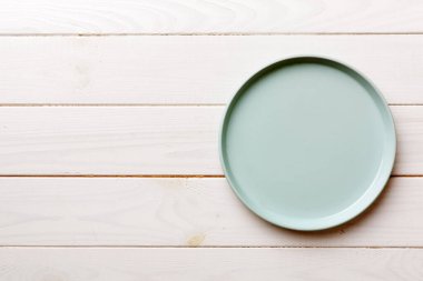 Ahşap zemindeki boş mavi tabağın üst görüntüsü. Tasarımın için boş boşluk.