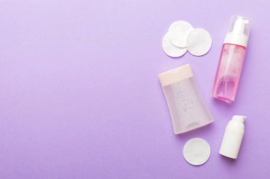 Kozmetikleri çıkarmak ve renkli arkaplandaki deriyi temizlemek için Micellar suyu ve diskleri temizler. Üst görünümü kopyala.