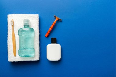 Masada banyo kozmetik ürünleri olan bir kompozisyon. jilet, diş macunu, sabun, jel, diş fırçası, gargara ve diğer çeşitli aksesuarlar. Cilt sağlığı için kozmetik. Logonuz için Bath Mockup.