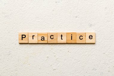 Tahta blokta yazılı alıştırma kelimesi. Çalışma metni masa üzerinde, konsept.