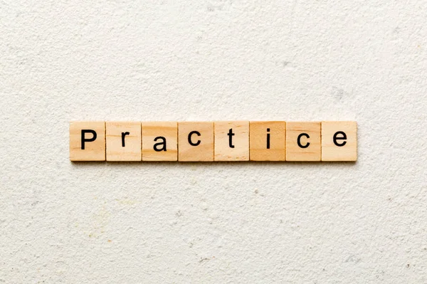 Tahta blokta yazılı alıştırma kelimesi. Çalışma metni masa üzerinde, konsept.