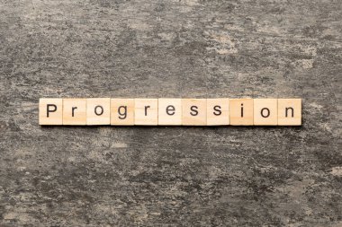 Tahta bloğa yazılmış bir kelime. desing, konsept için beton tablo üzerindeki ilerleme metni.