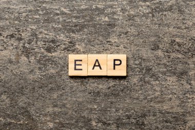 EAP word written on wood block. employee assistance program text on table, concept.