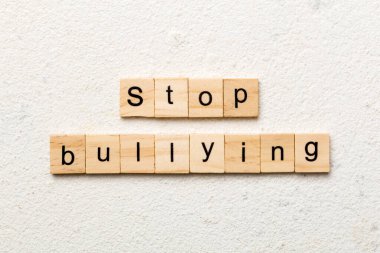 Ahşap blokta yazan sözlere sataşmayı bırak. Çimento masasında sataşmayı bırak, konsept.