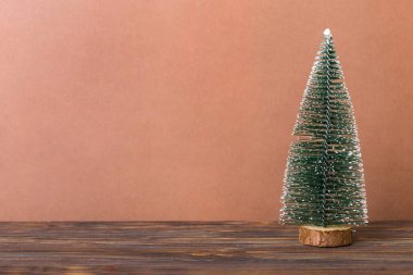 One small Christmas tree on colored background. new year decoration with copy space.