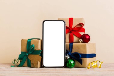 Digital phone mock up with rustic Christmas decorations for app presentation with empty space for you design. Christmas online shopping concept. Tablet with copy space on colored background.