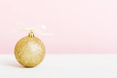 Christmas ball on colored background. decoration bauble with ribbon bow with copy space.