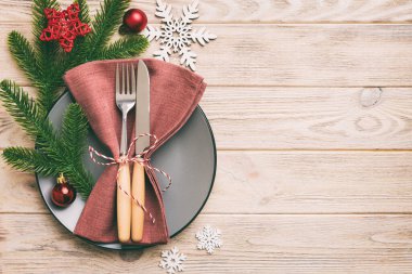 Noel süsleri, tabaklar, inekler, çatallar ve kaşıklarla Noel sofrası. Noel tatili geçmişi. Kopyalama alanı olan üst görünüm.