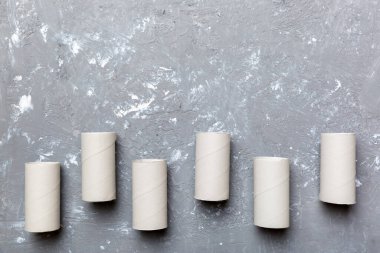 Boş tuvalet kağıdı ruloları ve renk arkaplanı üzerine metin için alanı olan düz bir kompozisyon. Kraft kağıdı veya kartondan yapılmış metal kapaklı geri dönüşümlü kağıt tüp.