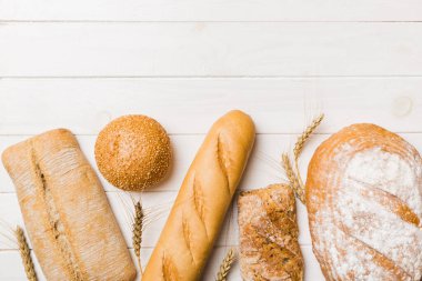 Ev yapımı doğal ekmek. Arka plan olarak farklı taze ekmek türleri, kopya alanı ile üst görünüm.