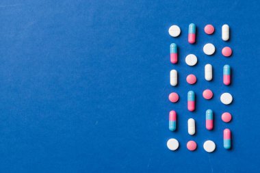 Renkli arka plan ve üst görünüm üzerine yazılmış metinler için birçok farklı hap ve alan. Renkli arka planda farklı haplar, düz yatış.