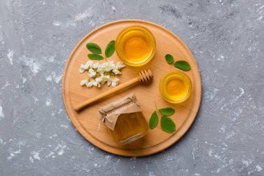 Akasya çiçekli ve yapraklı bal kavanozu. Taze bal üst görünüm düz yatıyordu.