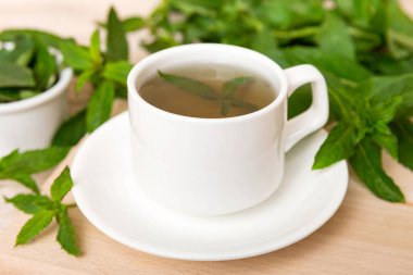Arka planda bir fincan nane çayı. Fotokopi alanı ile taze nane görünümlü yeşil çay.