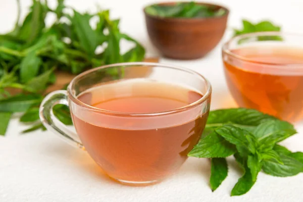 Cup of mint tea on table background. Green tea with fresh mint top view with copy space.