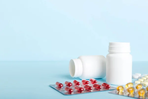Medicine for treatment HIV infection. Pills and capsules and battle on the table. Different colorful tablets at colored background with copy space.