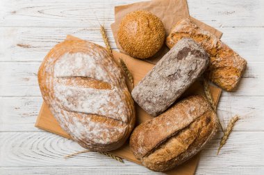 Kırsal masa manzaralı peçeteli taze pişmiş ekmek çeşitleri. Sağlıklı mayasız ekmek. Fransız ekmeği.