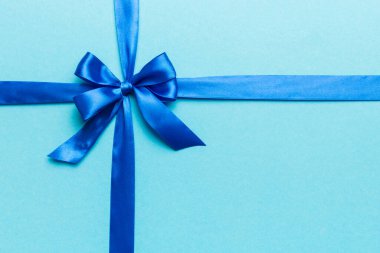 Mor kurdelenin üst görüntüsü yuvarlandı ve pembe fiyonk renkli arka planda izole edildi. Kopyalama alanı olan düz.