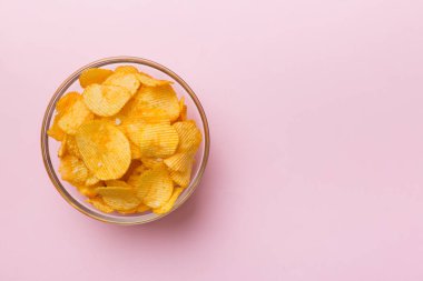 Renkli arka planda izole edilmiş patates cipsi. Lezzetli çıtır patates cipsi kasede. Mesaj için yer var. Üst görünüm.