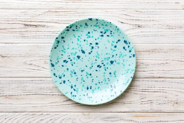 Ahşap zemindeki boş mavi tabağın üst görüntüsü. Tasarımın için boş boşluk.