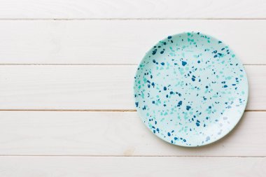 Ahşap zemindeki boş mavi tabağın üst görüntüsü. Tasarımın için boş boşluk.