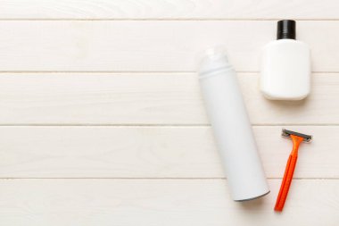 Tıraş Adam seti. Traş makinesi, havlu, losyon ve renkli arka planda tıraş köpüğü. Erkekler banyo aksesuarları üst görünüm.