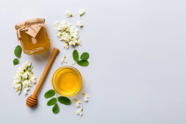 Akasya çiçekli ve yapraklı bal kavanozu. Taze bal üst görünüm düz yatıyordu.