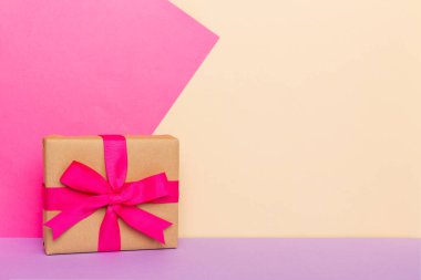 Tatil kağıdı hediyesi pembe kurdeleli pruva manzaralı fotokopi alanı. Tatil geçmişi düzdü. Doğum günü ya da Noel hediyesi. Kopya alanı olan Noel hediyesi kutusu konsepti.