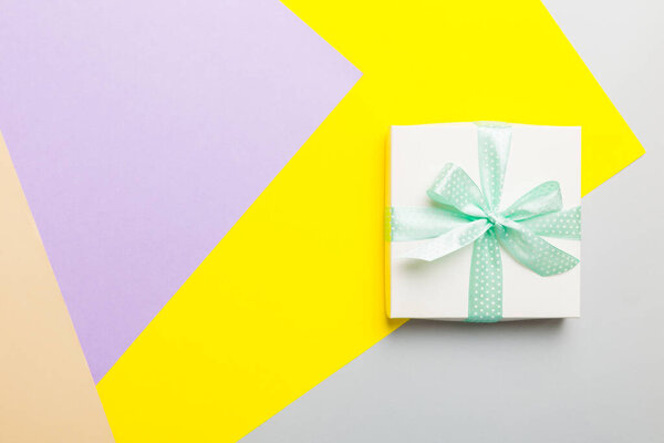holiday handmade white present tied green ribbon bow top view with copy space. Flat lay holiday background. Birthday or christmas present. Christmas gift box concept with copy space.