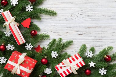 Noel süslemeleri, köknar ağacı dalları ve hediye kutusundaki karanlık masa. Kopyalama alanı olan üst görünüm çerçevesi.