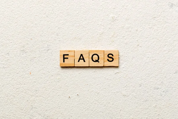 faqs word written on wood block. faqs text on table, concept.