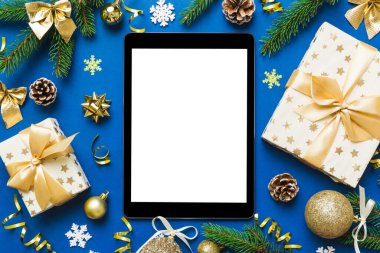 Digital tablet mock up with rustic Christmas decorations for app presentation top view with empty space for you design. Christmas online shopping concept. Tablet with copy space on colored background.