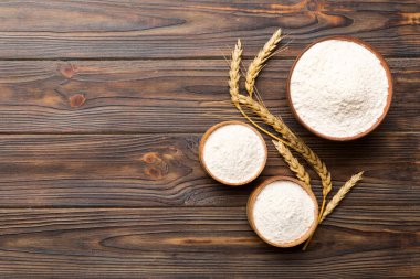 Tahta kasede buğday unu ve renkli arka planda buğday dikenleri. dünya buğday krizi.