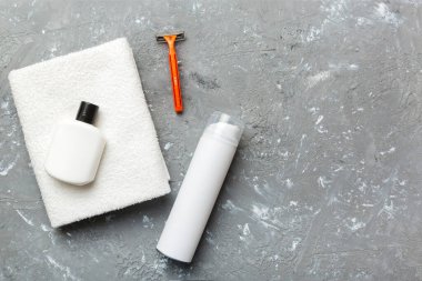 Tıraş Adam seti. Traş makinesi, havlu, losyon ve renkli arka planda tıraş köpüğü. Erkekler banyo aksesuarları üst görünüm.