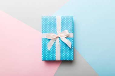 holiday handmade paper present tied white ribbon bow top view with copy space. Flat lay holiday background. Birthday or christmas present. Christmas gift box concept with copy space.