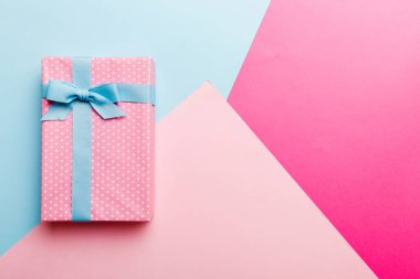 holiday handmade paper present tied blue ribbon bow top view with copy space. Flat lay holiday background. Birthday or christmas present. Christmas gift box concept with copy space.