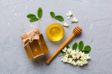 Akasya çiçekli ve yapraklı bal kavanozu. Taze bal üst görünüm düz yatıyordu.