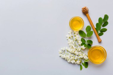 Akasya çiçekli ve yapraklı bal kavanozu. Taze bal üst görünüm düz yatıyordu.