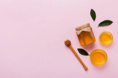 Bal kavanozu, beyaz arka plan manzaralı ve fotokopi alanı olan ahşap bal kaplama. Lezzetli bal şişesi.