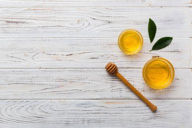 Bal kavanozu, beyaz arka plan manzaralı ve fotokopi alanı olan ahşap bal kaplama. Lezzetli bal şişesi.