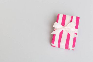 Noel 'i ya da diğer tatil hediyelerini renkli arka planda kurdeleyle renkli kağıda sardım. Şimdiki kutu, renkli tabloda hediye süslemesi, kopya alanı ile üst görünüm.