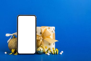 Digital phone mock up with rustic Christmas decorations for app presentation with empty space for you design. Christmas online shopping concept. Tablet with copy space on colored background.