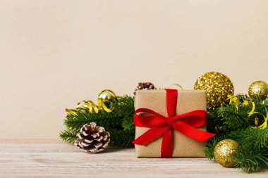New Year Christmas mood, gift box, branches of a christmas tree, New Year decorations on a colored background.