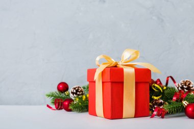New Year Christmas mood, gift box, branches of a christmas tree, New Year decorations on a colored background.