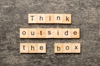 Tahta blokta yazan kutunun dışını düşün. Top view konseptin için çimento masasının üzerindeki kutu metnin dışında düşün..