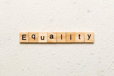 Tahta blokta yazan eşitlik kelimesi. Deksing, konsept için çimento tablosundaki eşitlik metni.