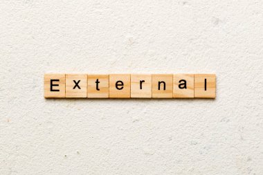 Tahta blokta EXTERNAL kelimesi yazıyor. Deksing, konsept için EXTERNAL metin çimento tablo üzerinde.