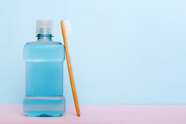 Mouthwash and other oral hygiene products on colored table top view with copy space. Flat lay. Dental hygiene. Oral care products and space for text on light background. concept.